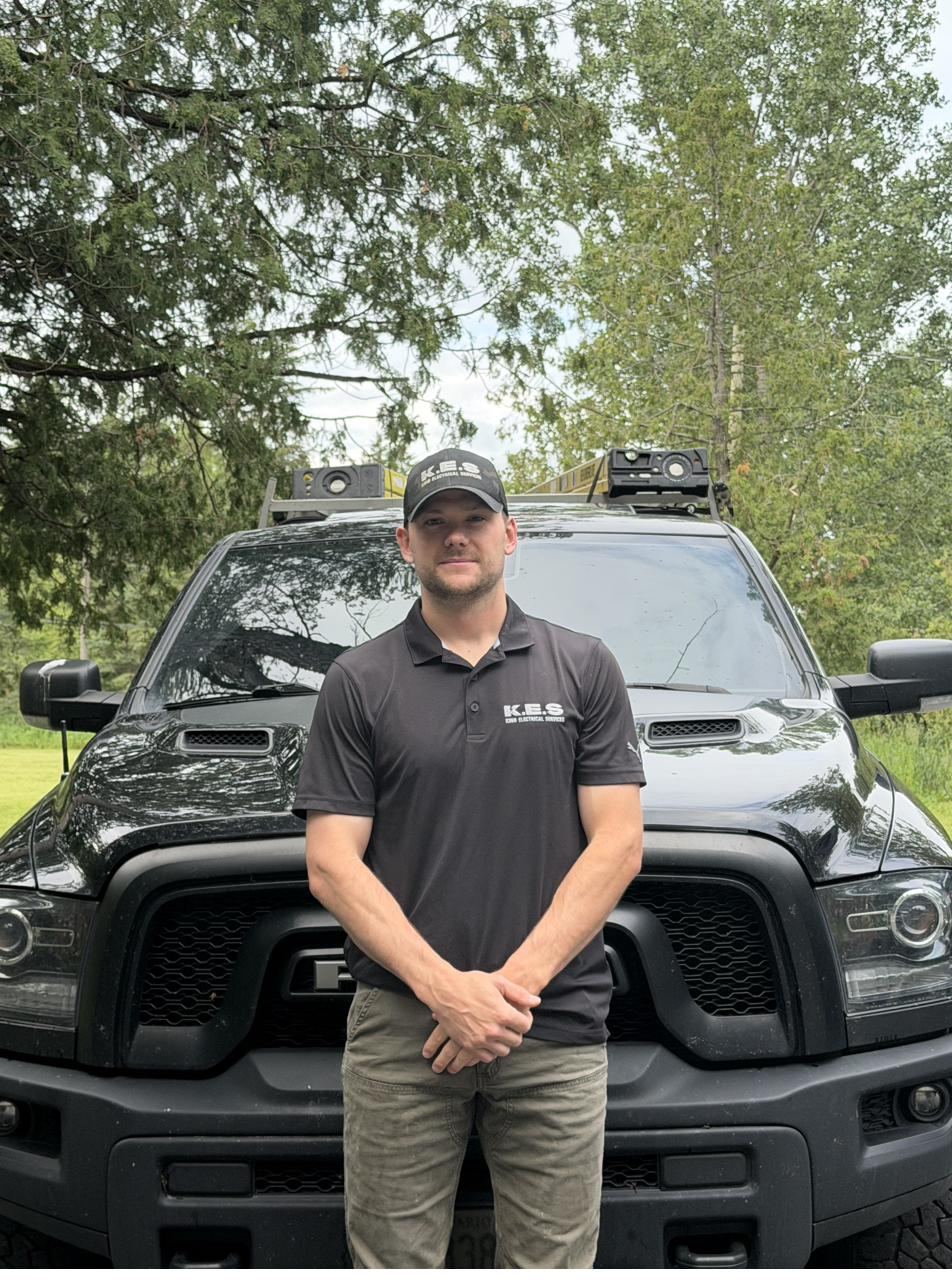 Chris King, licensed electrician and owner of King Electrical Services, standing in front of his truck